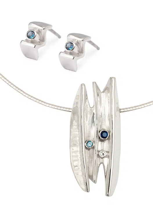 Designer jewellery set comprised of sterling silver earrings and pendant with blue topaz inspired by the shores of Orkney