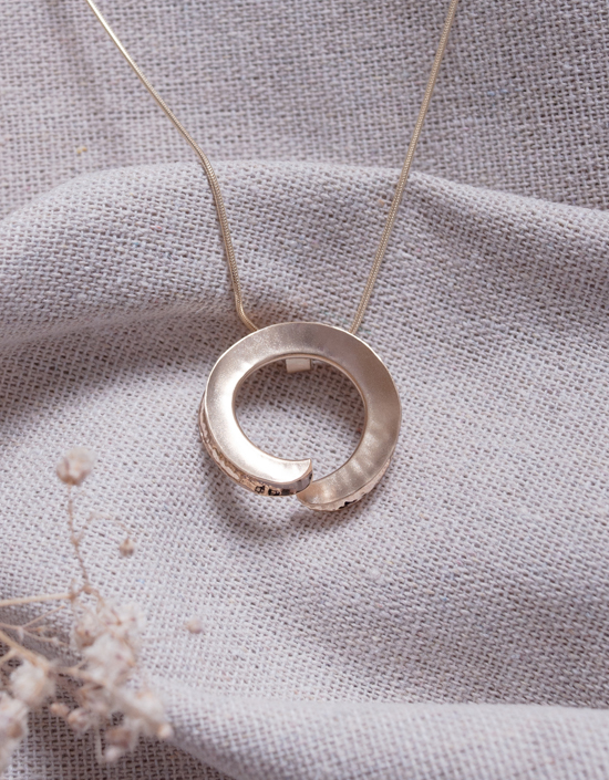 Handmade one of a kind sculptural pendant in solid 9ct yellow gold with a matte finish and polished fold, inspired by the Orkney coastline.