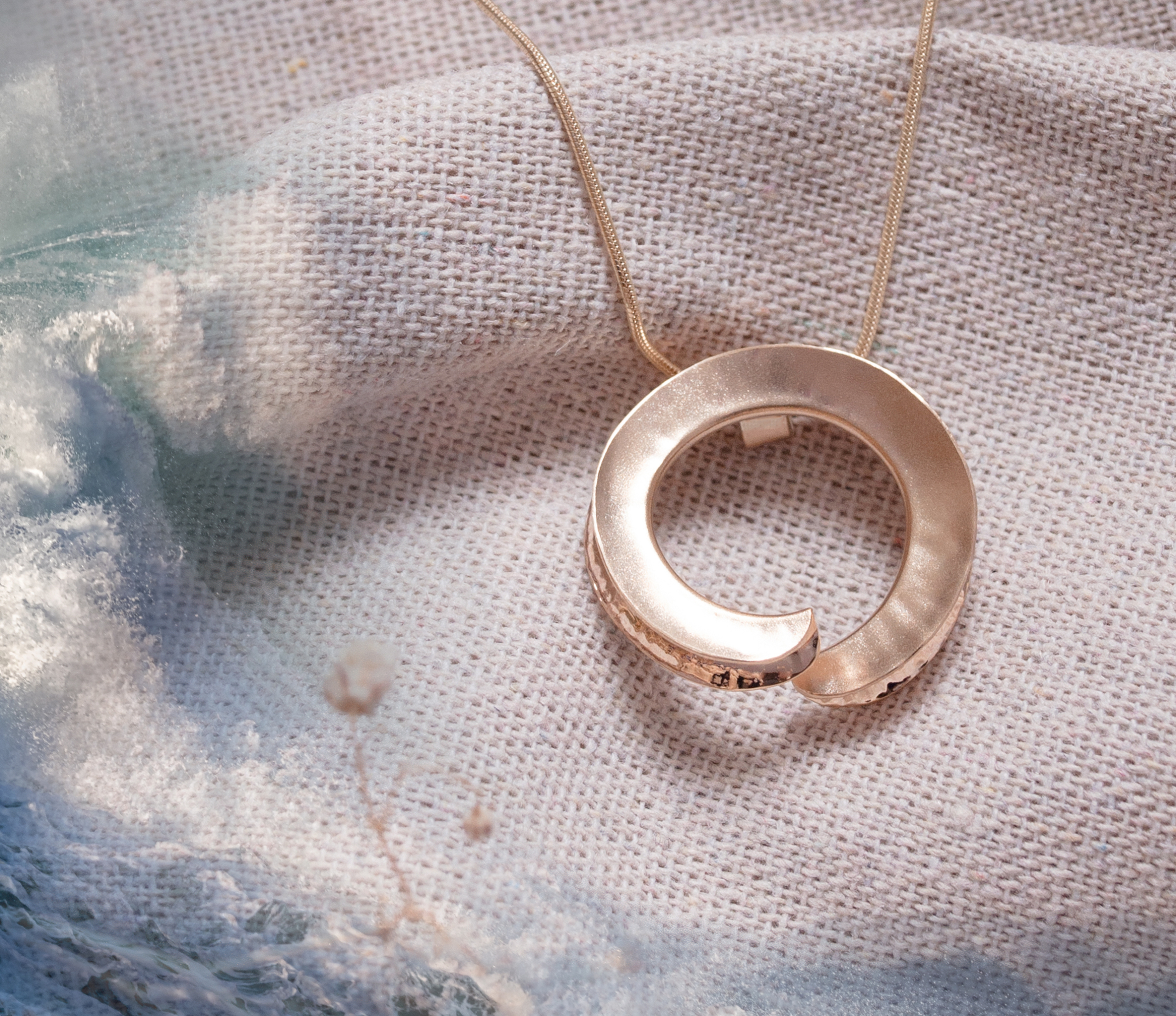 Gold sculptural pendant and Atlantic waves in an Orkney-inspired jewellery banner by Zoe Davidson Jewellery.