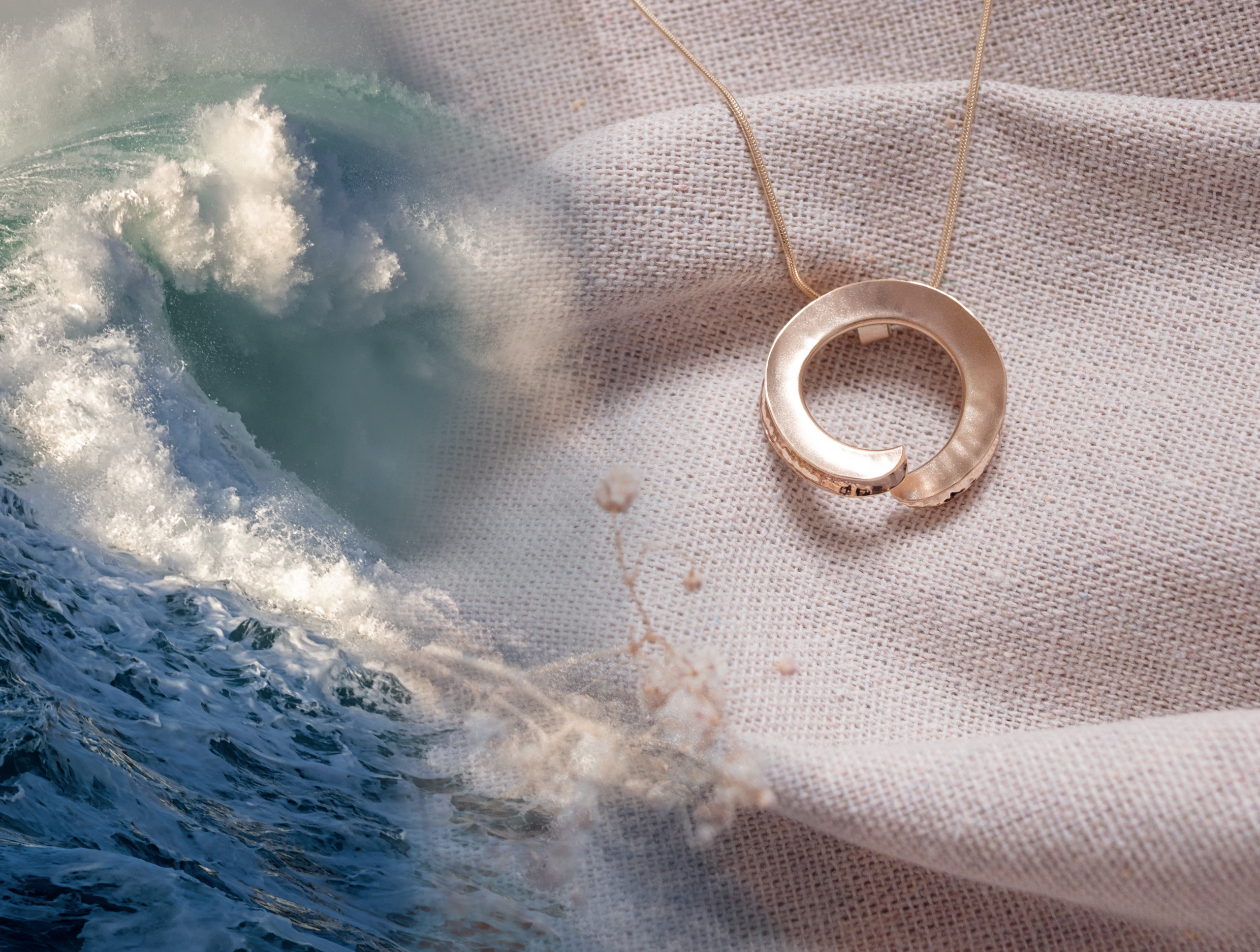 Gold sculptural pendant beside crashing Atlantic waves, inspired by Orkney’s seas, for Zoe Davidson Jewellery.